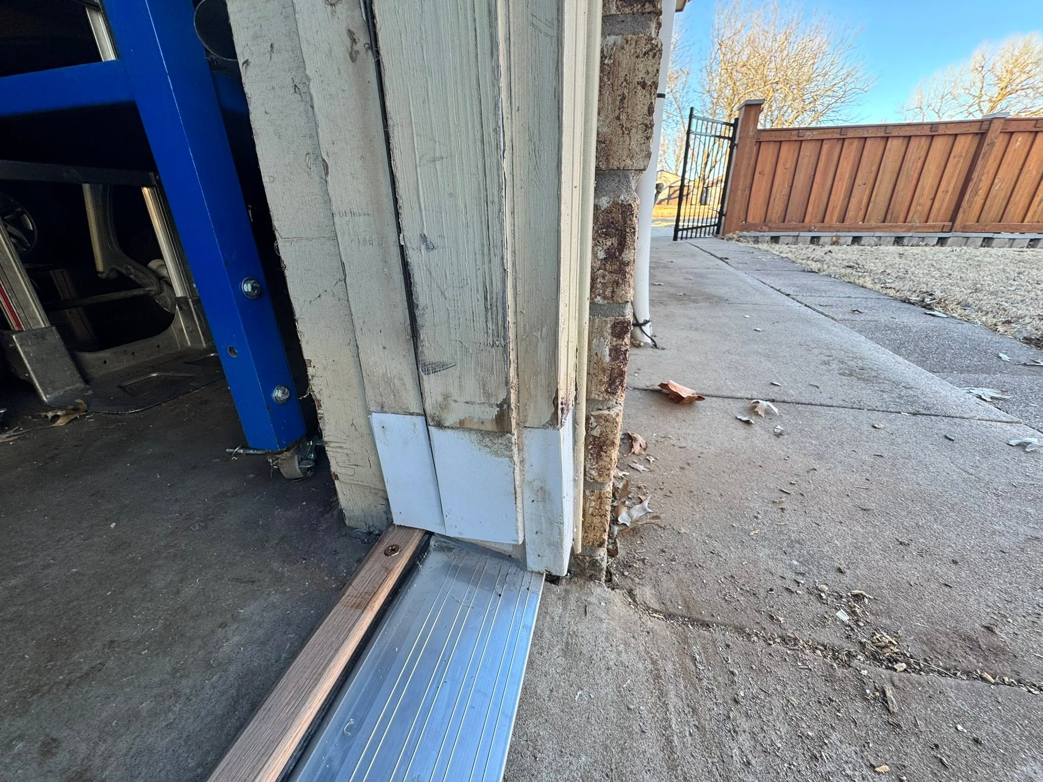 Garage door jamb and trim repair beside a brick column