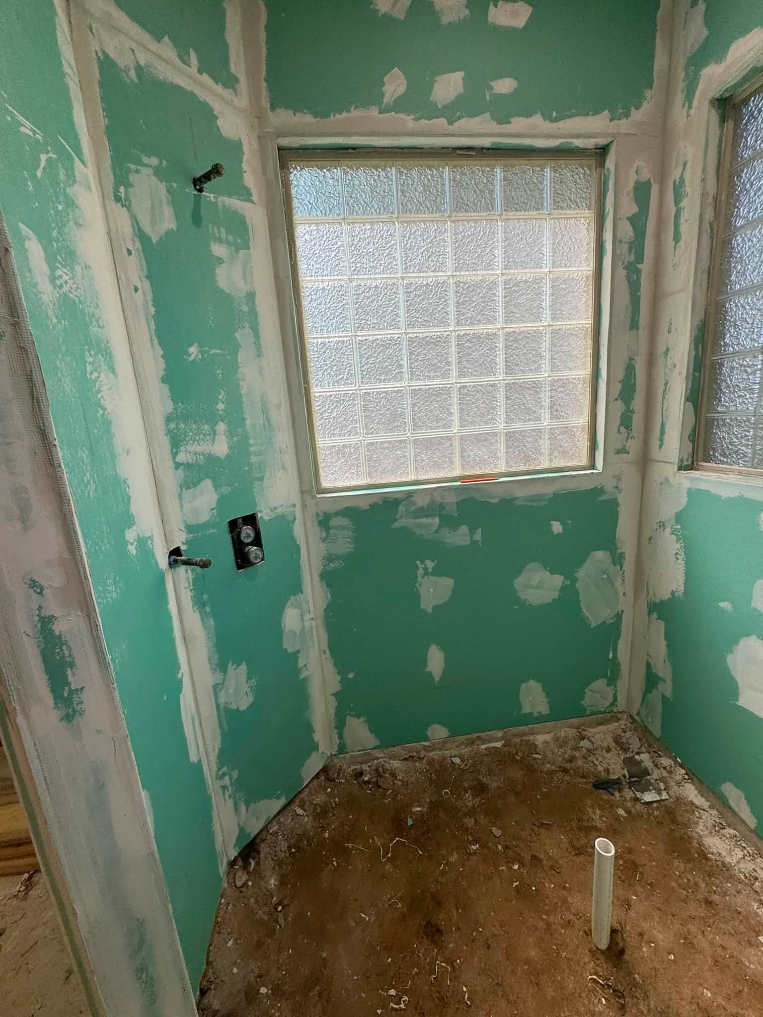 Green moisture-resistant drywall installed in a shower surround
