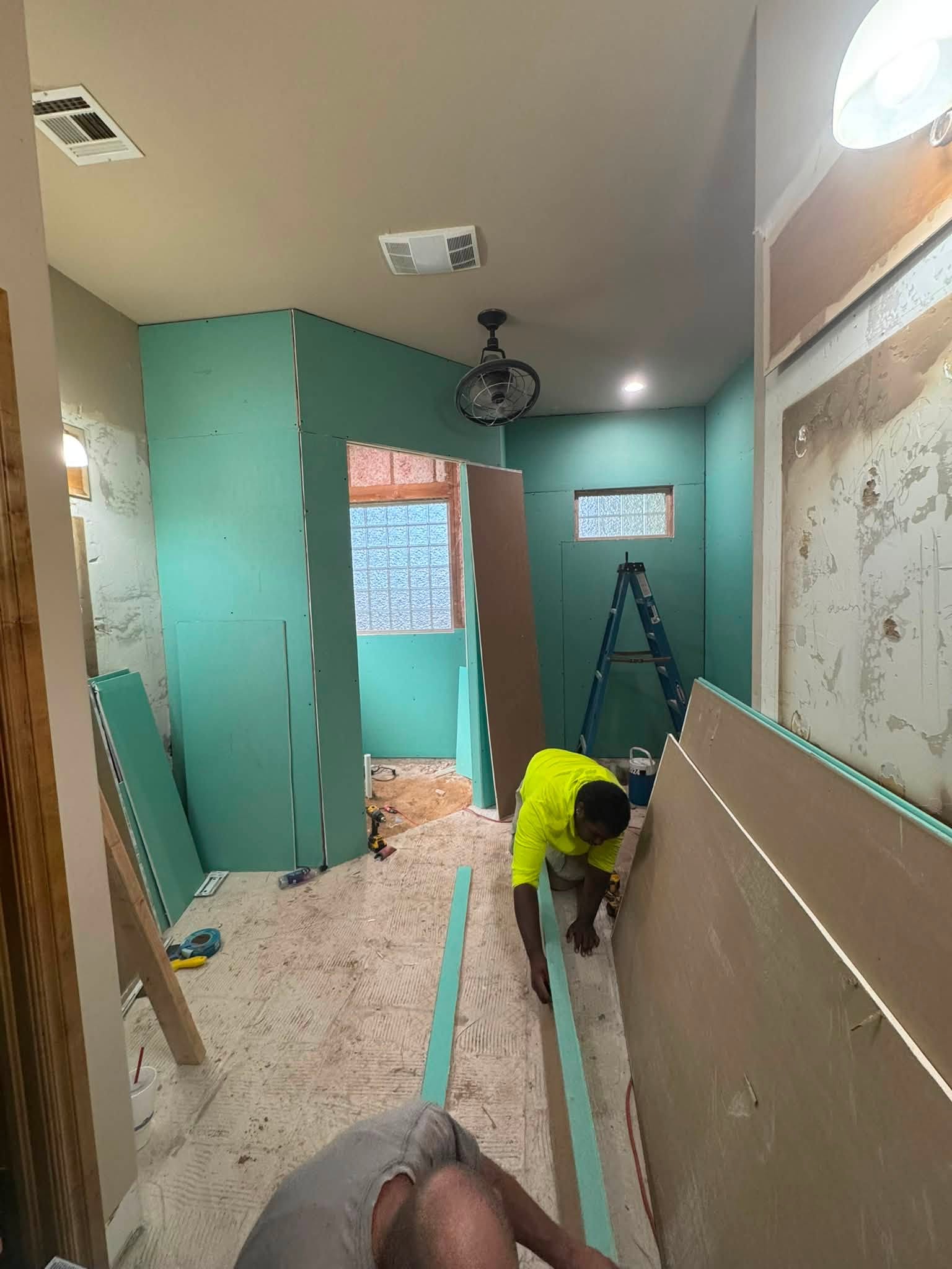 Crew hanging drywall sheets during an interior remodel