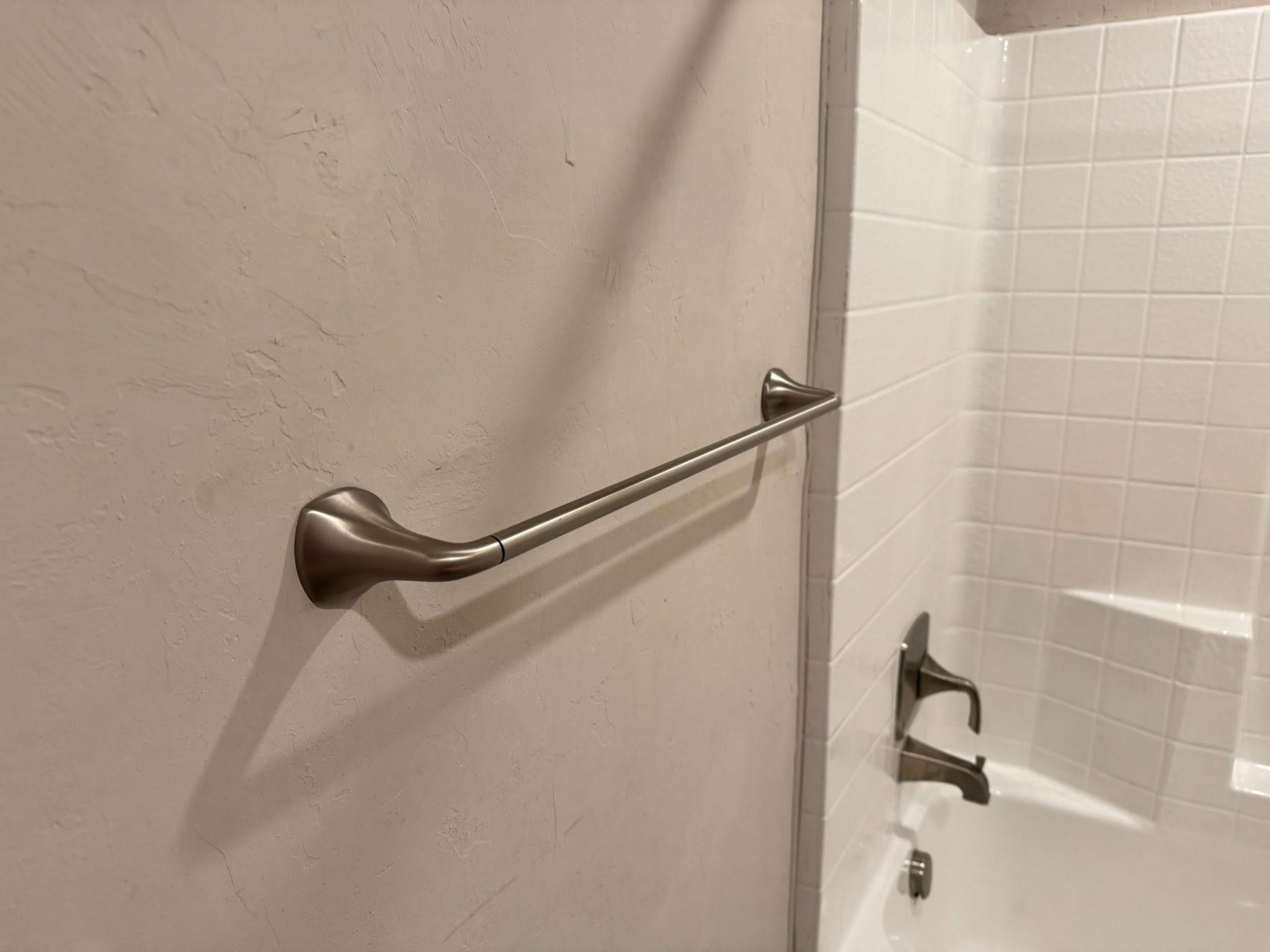 Grab bar mounted beside a bathtub